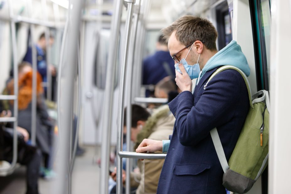 Sick man on subway wearing mask
