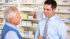 Pharmacist explains medicine to old man