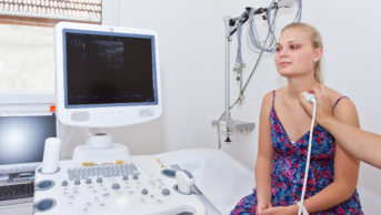 Woman having an ultrasound thyroid scan