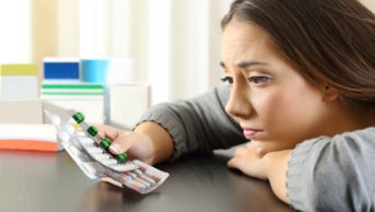 woman looking at pills
