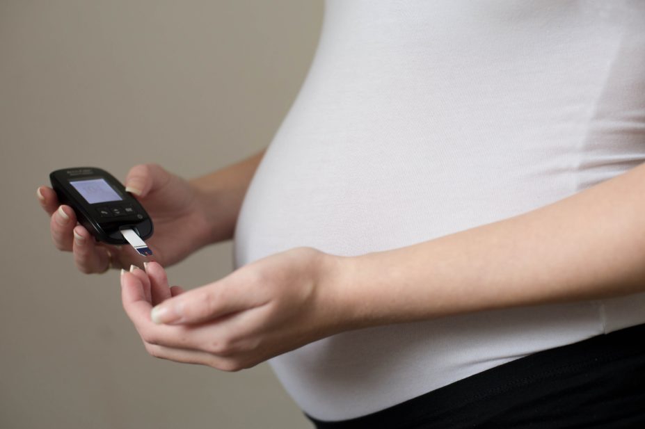 Woman with gestational diabetes testing her blood glucose