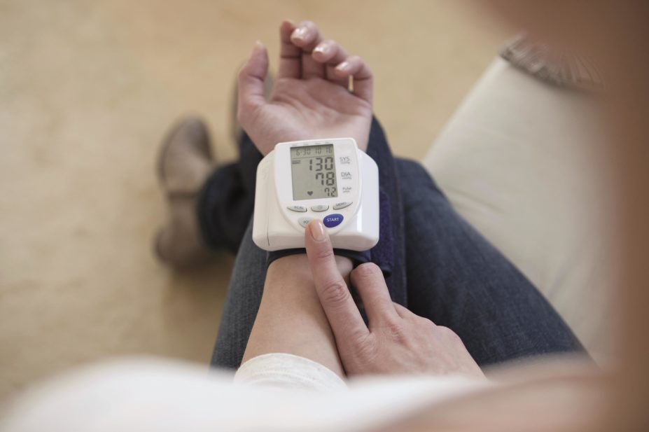 Intensive blood pressure (BP) reduction is more beneficial for patients than less intensive BP reduction, concludes research. In the image, woman takes her blood pressure