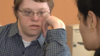 Boy with Down's Syndrome listens to a healthcare worker