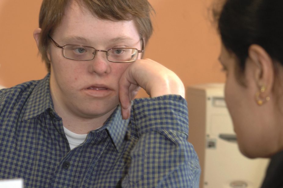 Boy with Down's Syndrome listens to a healthcare worker