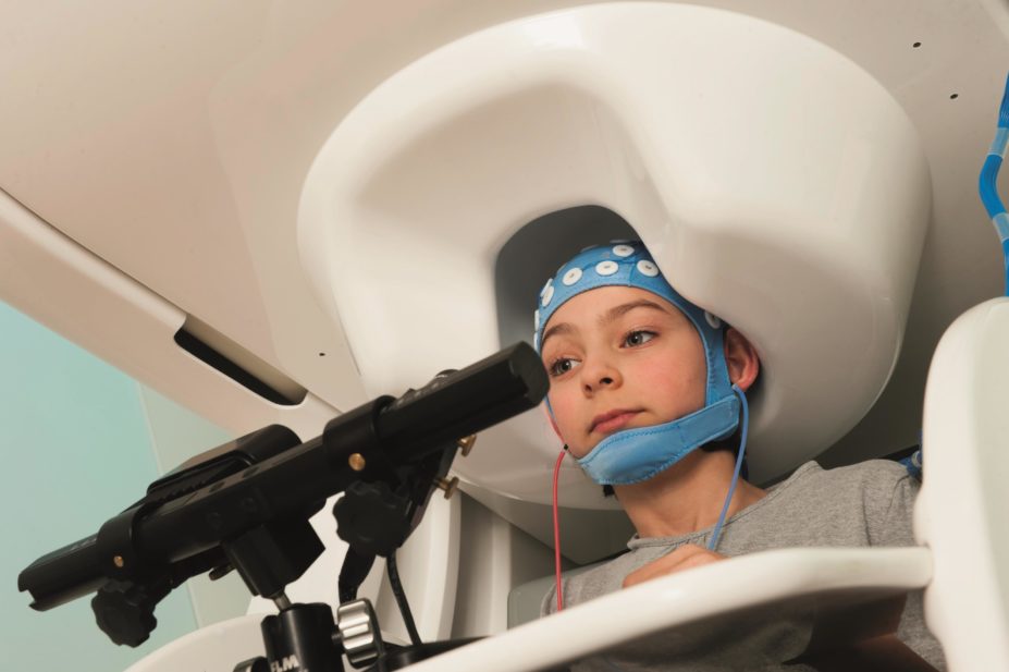 Diagnosing epilepsy in children and strategies for the selection of appropriate drug treatments. In the image, a 9-year old girl in a magnetoencephalograph (MEG) scanner, which is used to detect neurological disorders such as epilepsy