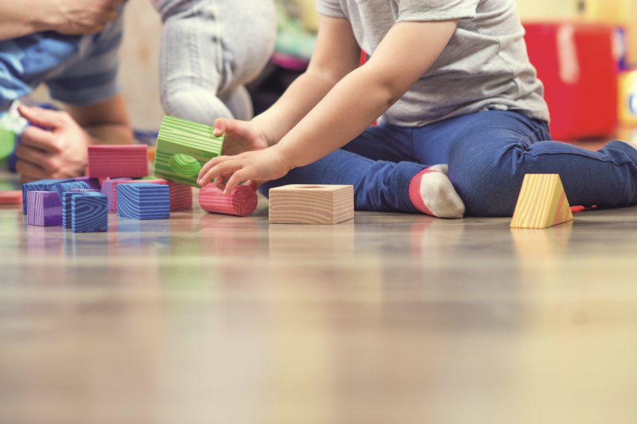 Child playing on floor with building blocks