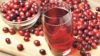 Glass of cranberry juice surrounded by cranberries