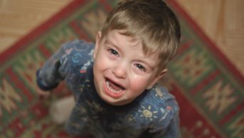 Inattention and hyperactive/impulsive symptoms are commonly seen in practice, with up to 6% of children meeting criteria for attention deficit hyperactivity disorder (ADHD). In the image, a crying child looks at the camera