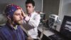 Daniel Randles, author of the research, sets up a participant to the EEG equipment used for the study