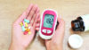 hand holding diabetes drugs and glucometer