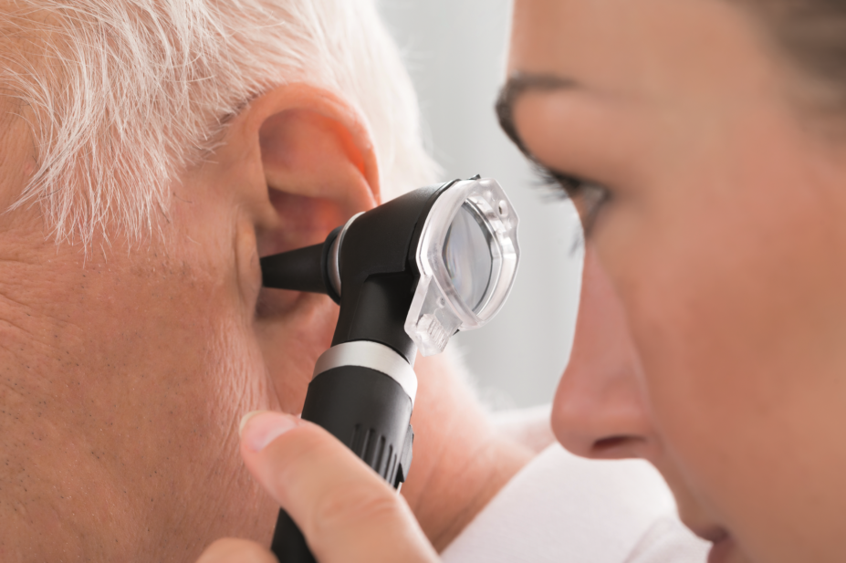 A doctor checks an elderly patient's ear