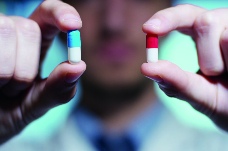 Doctor holding two identical pills generic concept