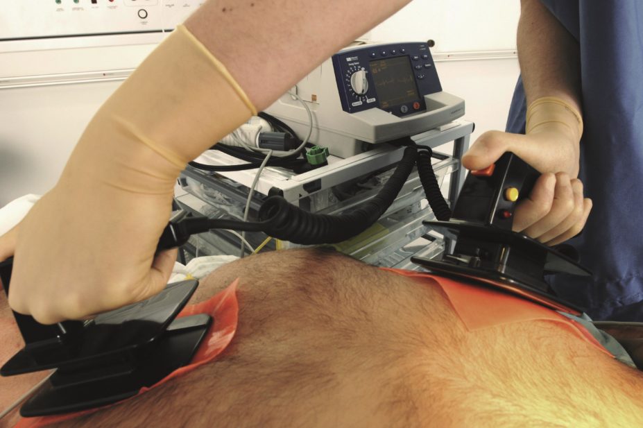Doctor uses a defibrillator on a patient
