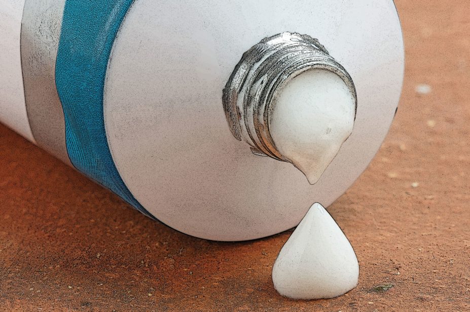 Close up of a drop of ointment cream coming out of tube