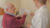 Elderly man consults with a carer about his medicines