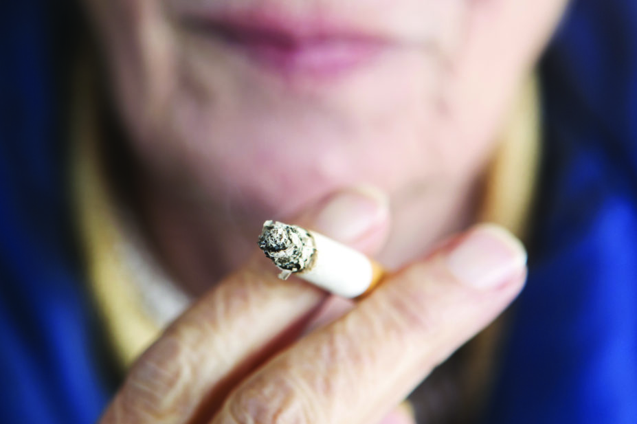 Older woman holding lighted cigarette