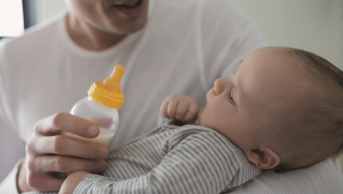 Father giving baby bottled milk