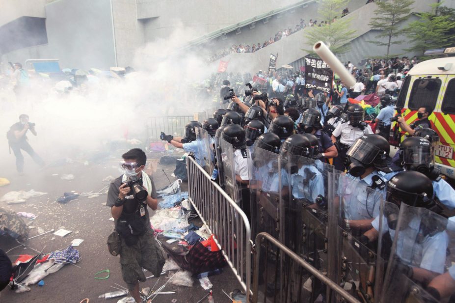 Police in Hong Kong are using tear gas and pepper spray to control thousands of protesters, who have taken to the streets to demonstrate against the government’s role in selecting candidates to lead Hong Kong