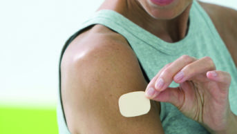 Older woman applying hormone replacement therapy patch