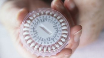 Close up of a woman's hand holding hormone replacement therapy (HRT) pills