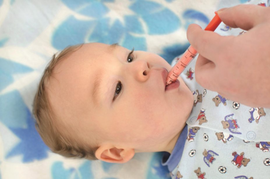 Babies receiving the meningitis B vaccine (Bexsero) should be given three doses of infant paracetamol as a prophylactic measure against fever, according to Public Health England (PHE). In the image, infant takes medicine from syringe