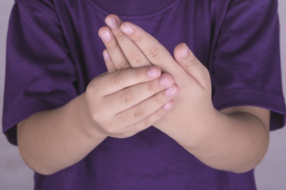 A recent study identified an association between childhood antibiotic exposure and subsequent development of juvenile idiopathic arthritis (JIA). In the image, a young child holds out his hands