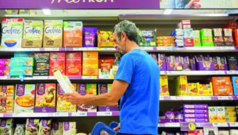 Man looking at gluten free products in a supermarket