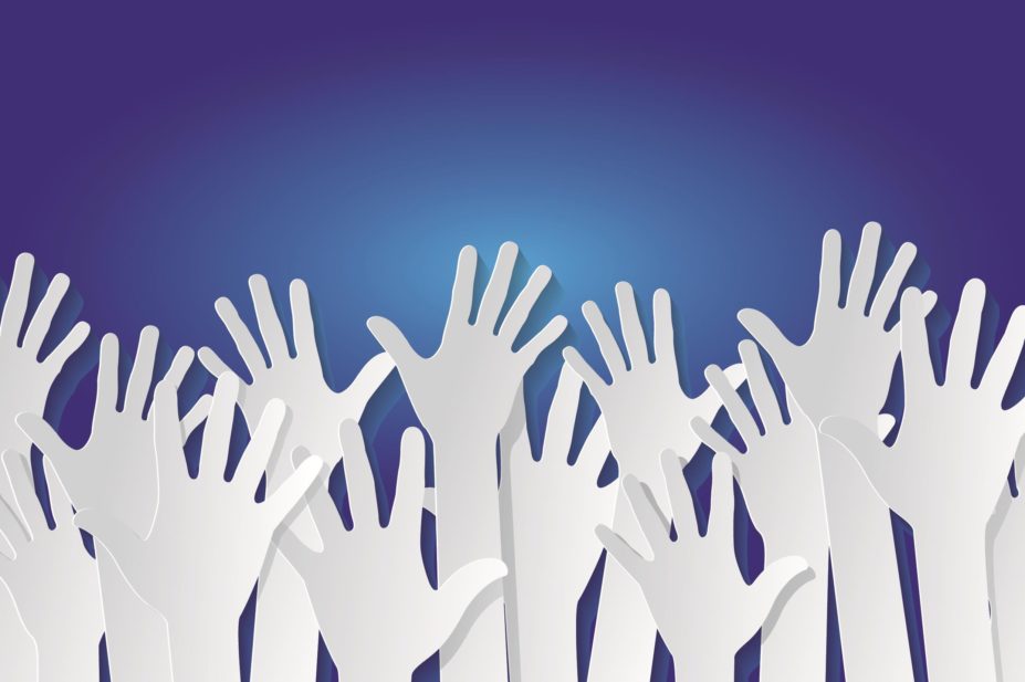 Many raised hands against a blue background