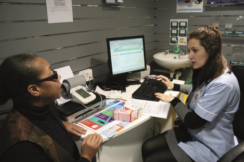 Pharmacist speaks with patient in consultation room