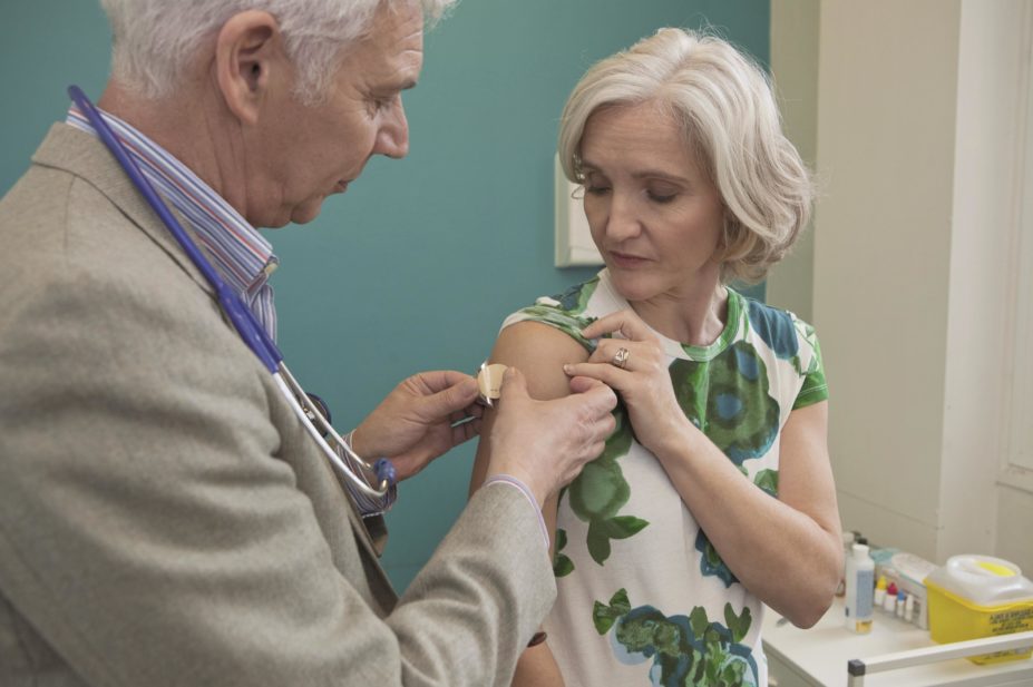 Doctor applying a nicotine patch to an older woman's arm