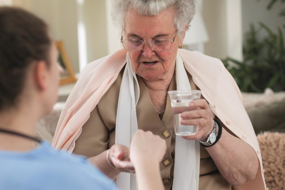 Care home staff giving a resident their medicine