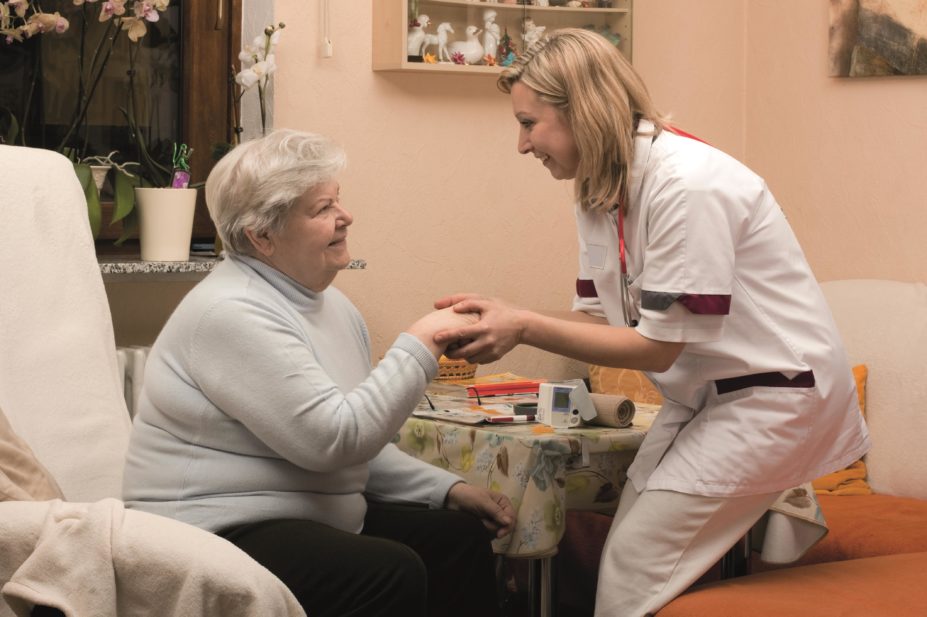 A nursing staff member helping an older patient