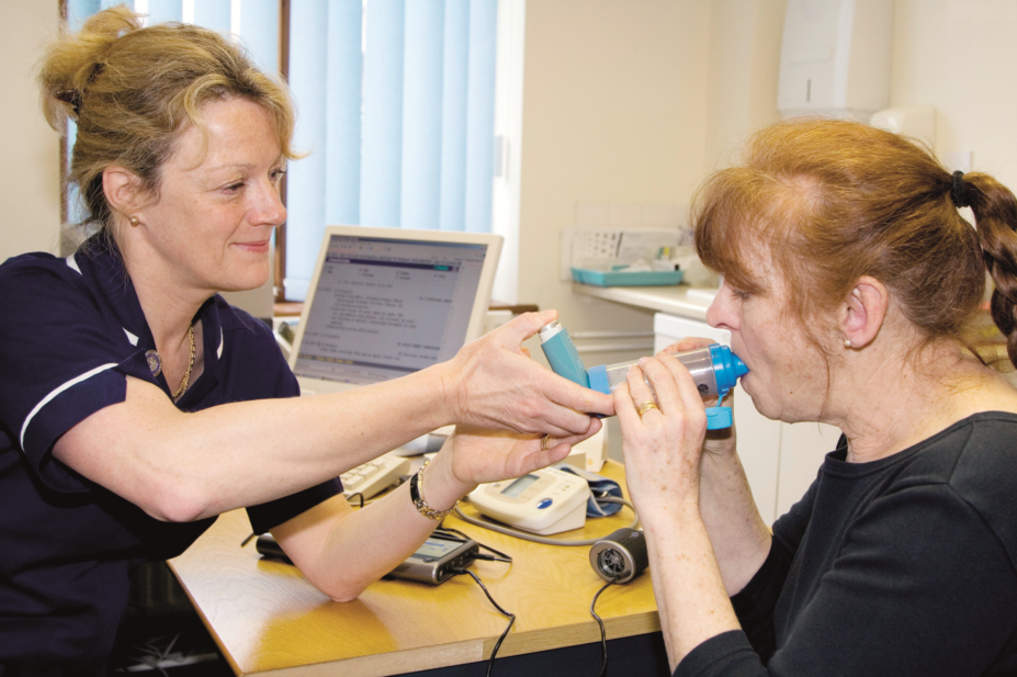 A nurse teaching a patient how to use an inhaler