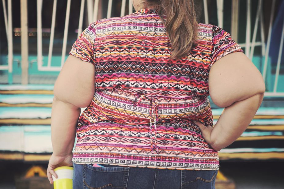 Obese woman, from behind, holding a large drink