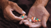 Old person holding pills