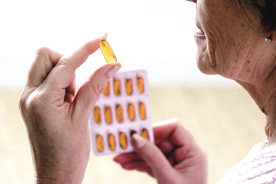 Using supplements of omega-3 fatty acids or of other nutrients found in green leafy vegetables does not slow down cognitive decline in older people, according to research. In the image, an elderly woman takes an omega-3 capsule