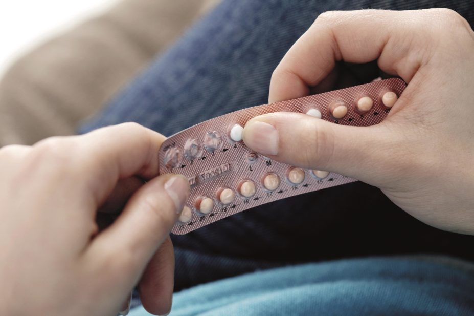 Woman holding card of contraceptive pills