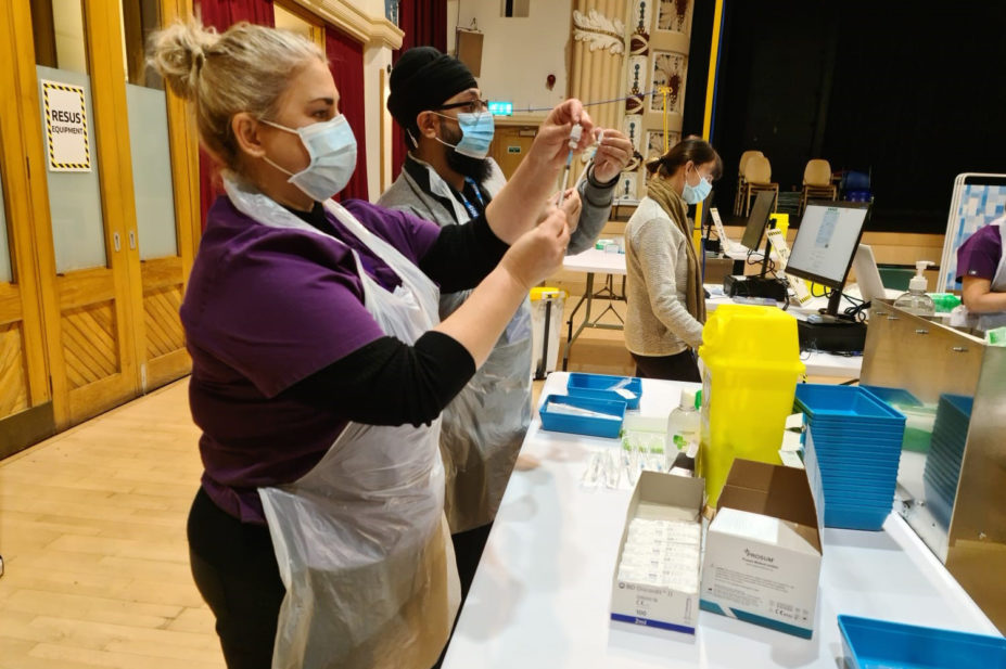 pharmacy team preparing vaccines in a hall