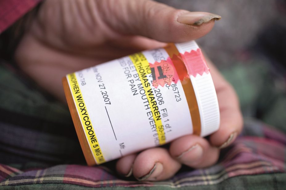 Long-acting opioid formulations, such as Oxycontin (slow release oxycodone), should be favoured for chronic pain over frequent short-acting formulations. In the image, a drug addict holds an oxycodone medicine bottle