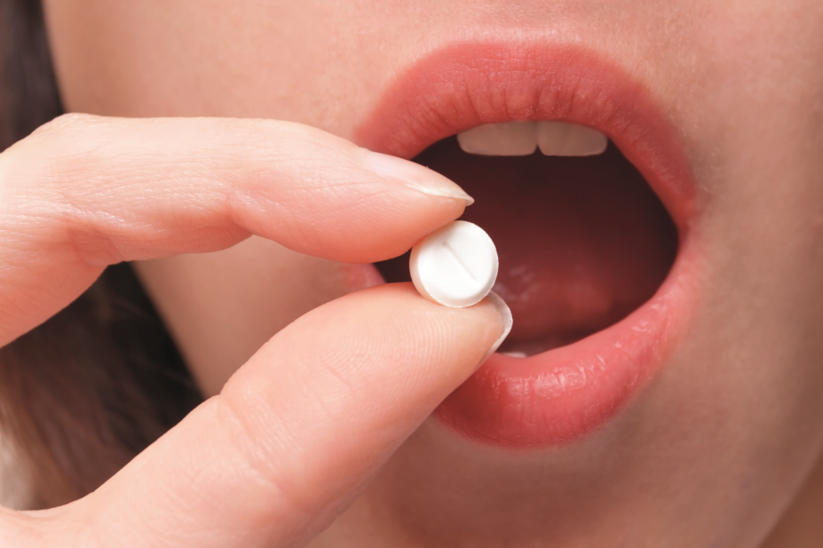 Close up of woman taking ibuprofen tablet
