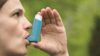 Person using salbutamol asthma inhaler