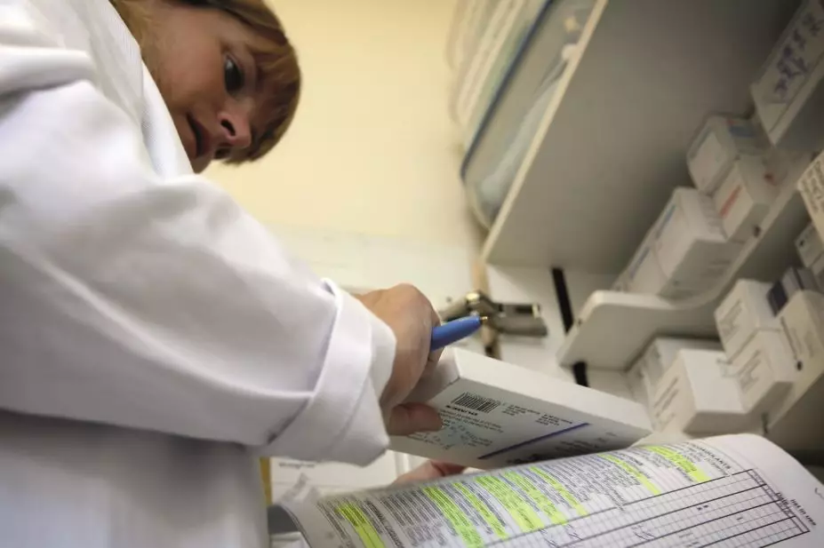 Pharmacist stocks and checks various drugs