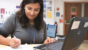 Pharmacist taking notes in front of a computer