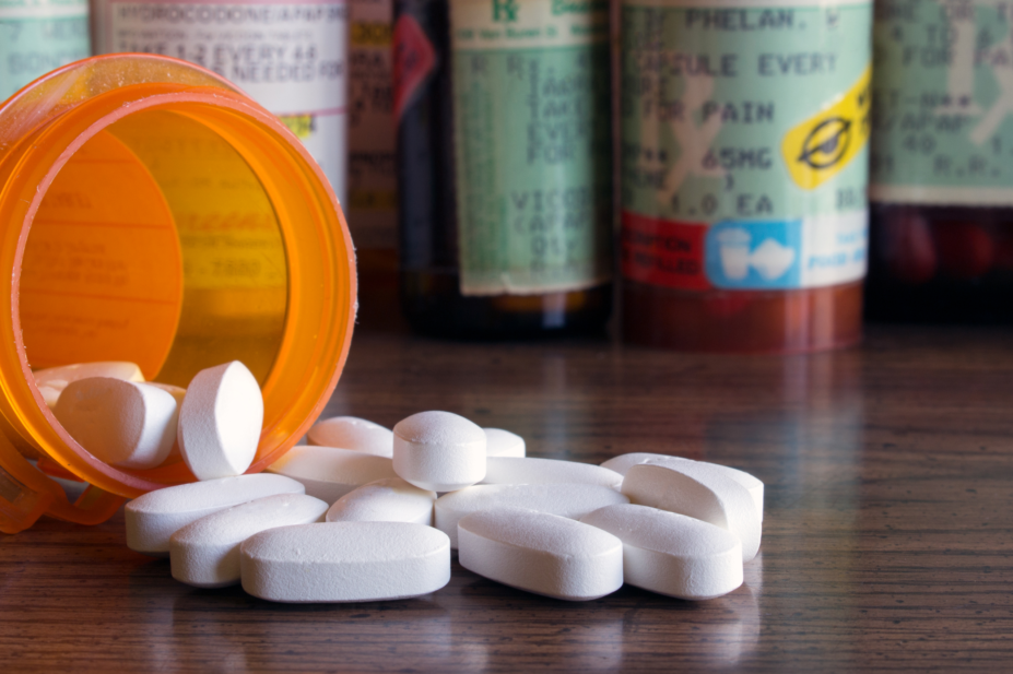 Opioid pills spilling out of pill bottle