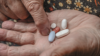 Close-up of pills on an elderly person's hands
