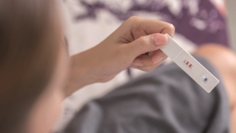 Woman holds a positive pregnancy test