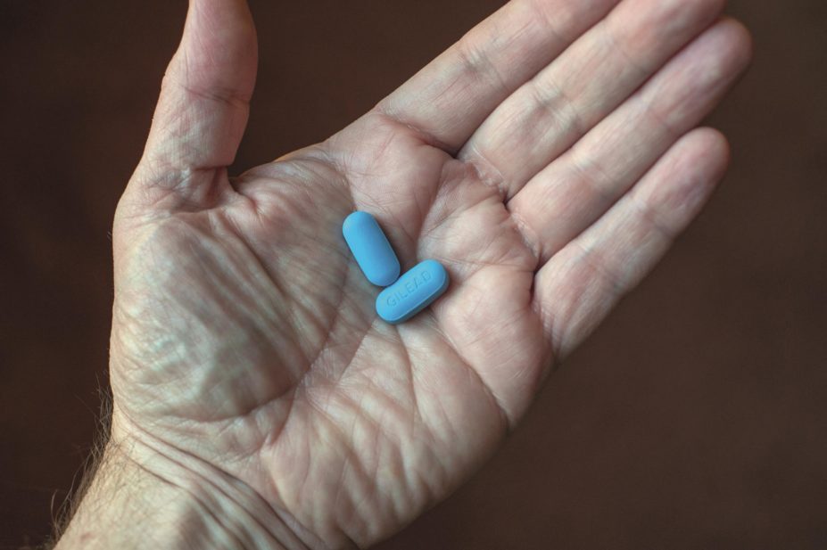 Hand holding two pre-exposure prophylaxis (PrEP) Truvada pills, manufactured by Gilead