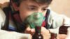 Pre-teen boy using an inhaler