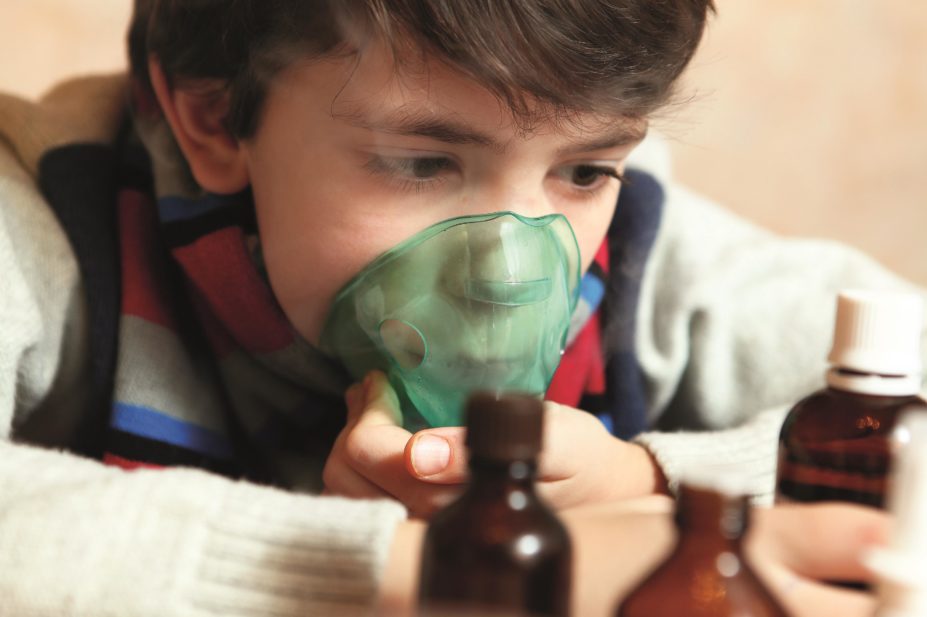 Pre-teen boy using an inhaler