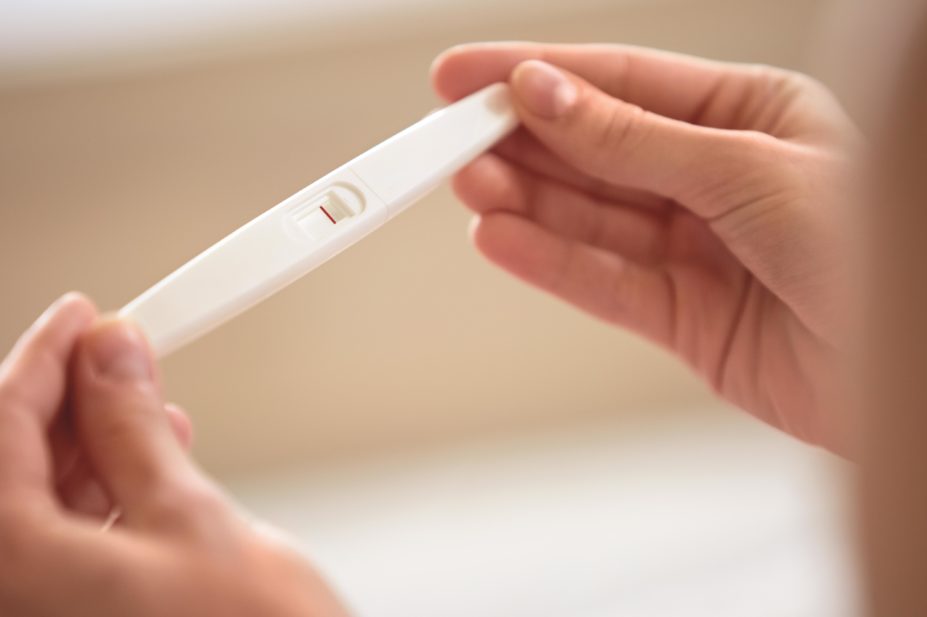 Study warns that women who hope to become pregnant should steer clear of non-steroidal anti-inflammatory pain killers (NSAIDs), because they prevent ovulation in as many as 75% of fertile women. In the image, a woman holds up a negative pregnancy test